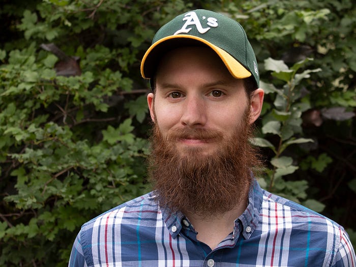 Ron Stauffer wearing a green baseball cap with a full ginger beard