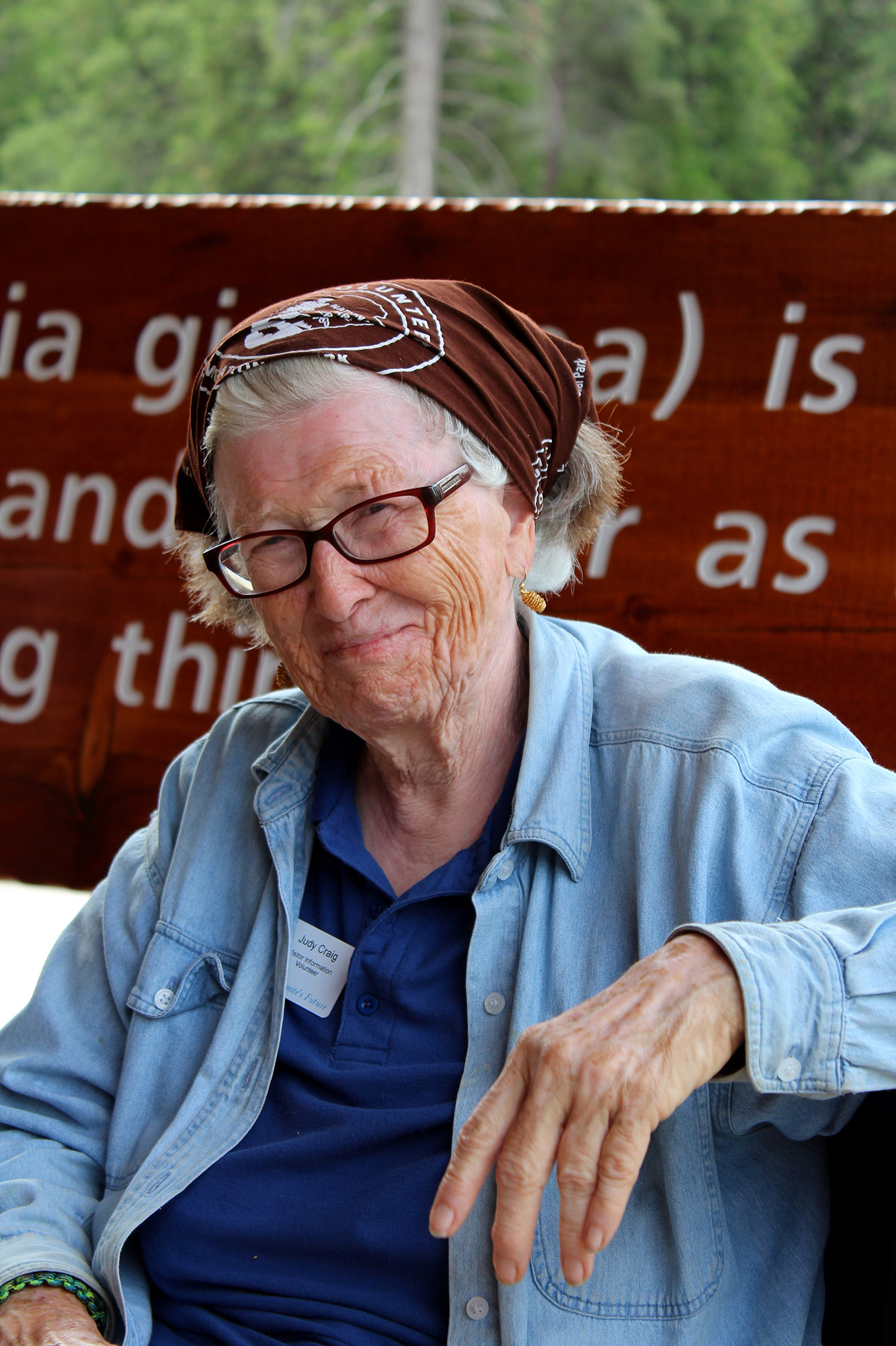 A woman in her sixties with a beautifully wrinkled face smiles at the camera